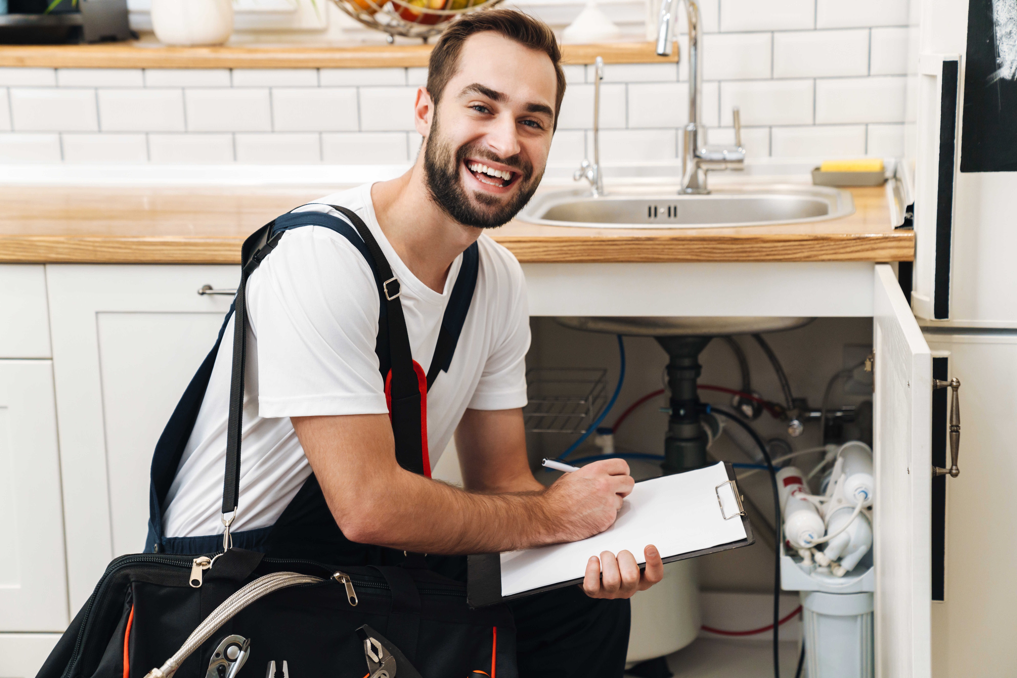 Professional plumber with tools and clipboard ready to serve Arvada customers